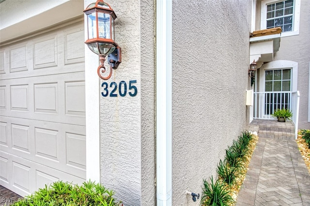 property entrance featuring a garage and stucco siding