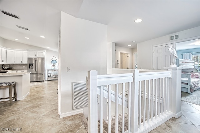 hall with lofted ceiling, an upstairs landing, visible vents, and recessed lighting