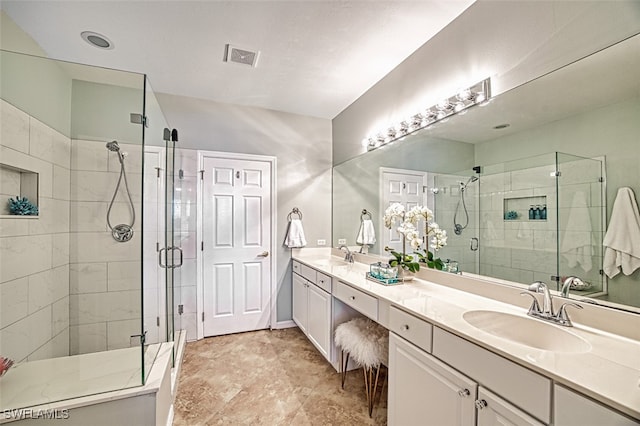 full bath with a stall shower, visible vents, a sink, and double vanity