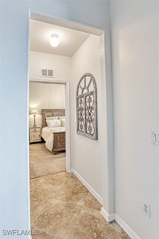 hallway with visible vents and baseboards