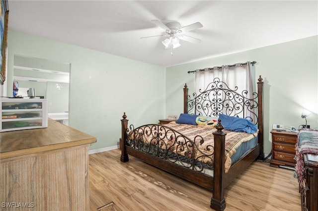 bedroom featuring ceiling fan, light wood-style flooring, and baseboards