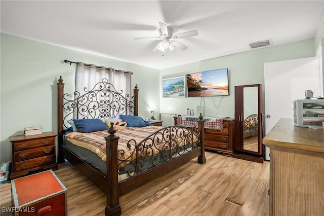 bedroom with light wood-style floors, visible vents, and a ceiling fan