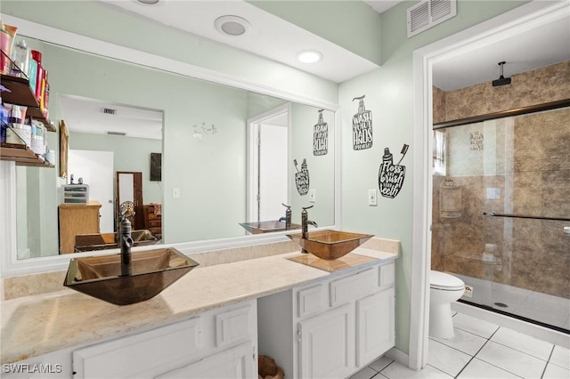 bathroom featuring visible vents, a sink, and a shower stall