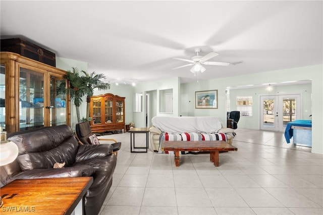 living area with light tile patterned floors, french doors, and a ceiling fan