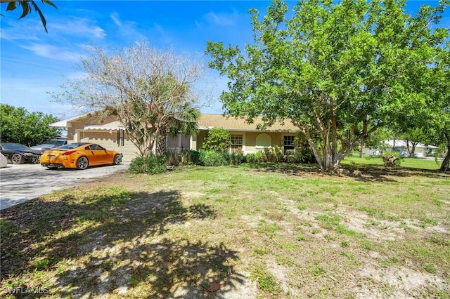 view of front of property featuring driveway, an attached garage, a front yard, and stucco siding