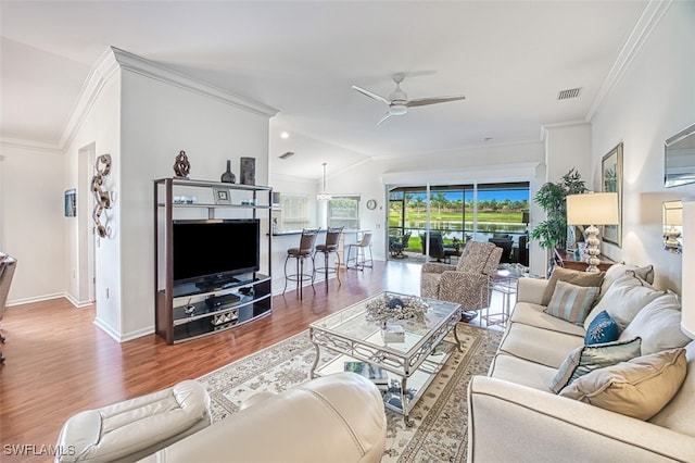 living area featuring ornamental molding, ceiling fan, wood finished floors, and visible vents