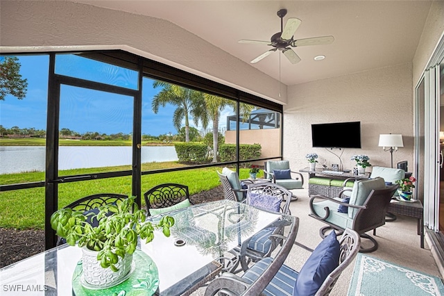 sunroom featuring lofted ceiling, a ceiling fan, and a water view