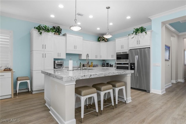 kitchen with white cabinets, an island with sink, and stainless steel appliances