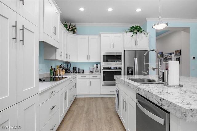 kitchen featuring appliances with stainless steel finishes, hanging light fixtures, ornamental molding, sink, and white cabinetry