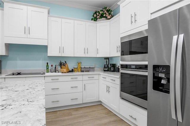 kitchen with white cabinetry, light wood-type flooring, light stone countertops, appliances with stainless steel finishes, and crown molding