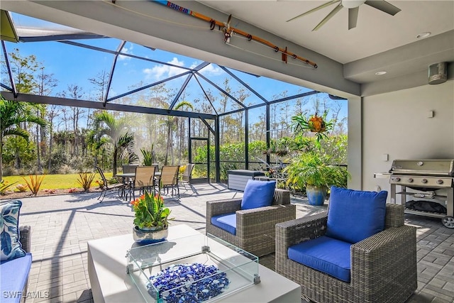 view of patio with area for grilling, glass enclosure, outdoor lounge area, and ceiling fan