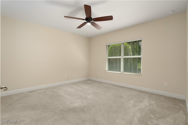 carpeted spare room featuring ceiling fan