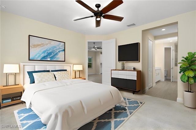 carpeted bedroom featuring ceiling fan and ensuite bath