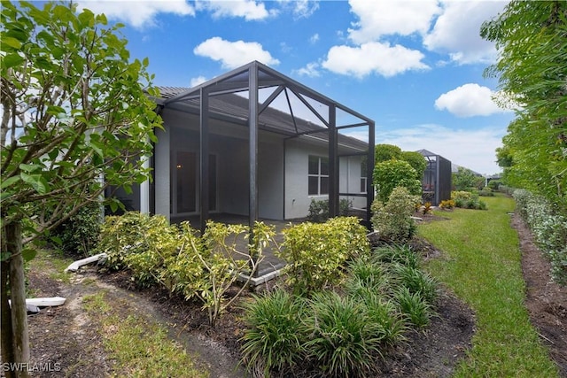 view of side of property featuring a patio and a lanai