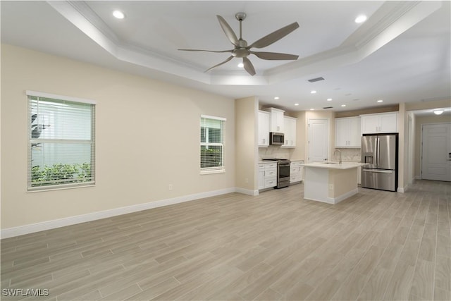 kitchen featuring white cabinetry, a kitchen island with sink, stainless steel appliances, and a raised ceiling