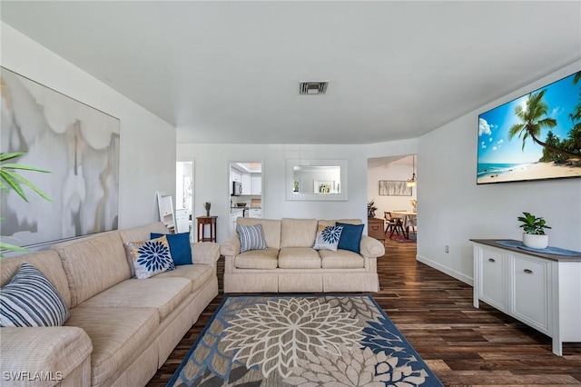 living room with dark wood-type flooring, visible vents, and baseboards