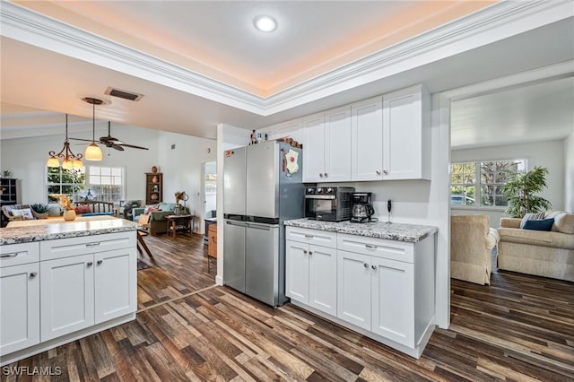 kitchen featuring freestanding refrigerator, open floor plan, white cabinets, and visible vents