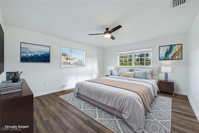 bedroom featuring dark wood-style floors, baseboards, visible vents, and a ceiling fan