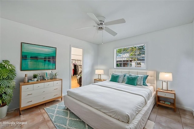 bedroom with a closet, a walk in closet, and a ceiling fan