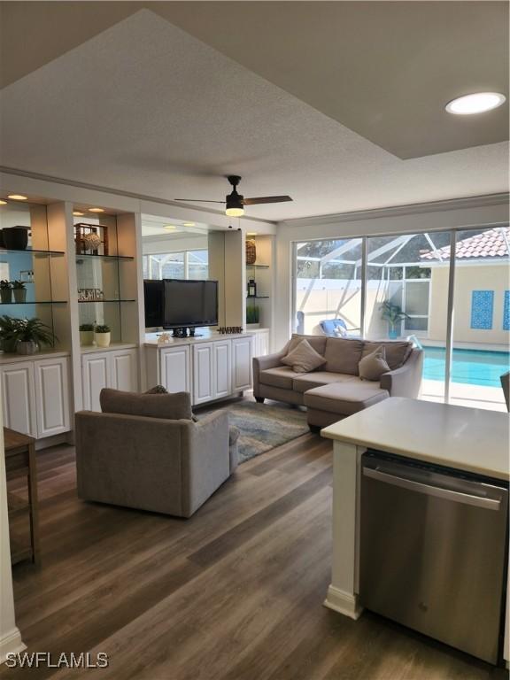living area with dark wood-style floors and a ceiling fan
