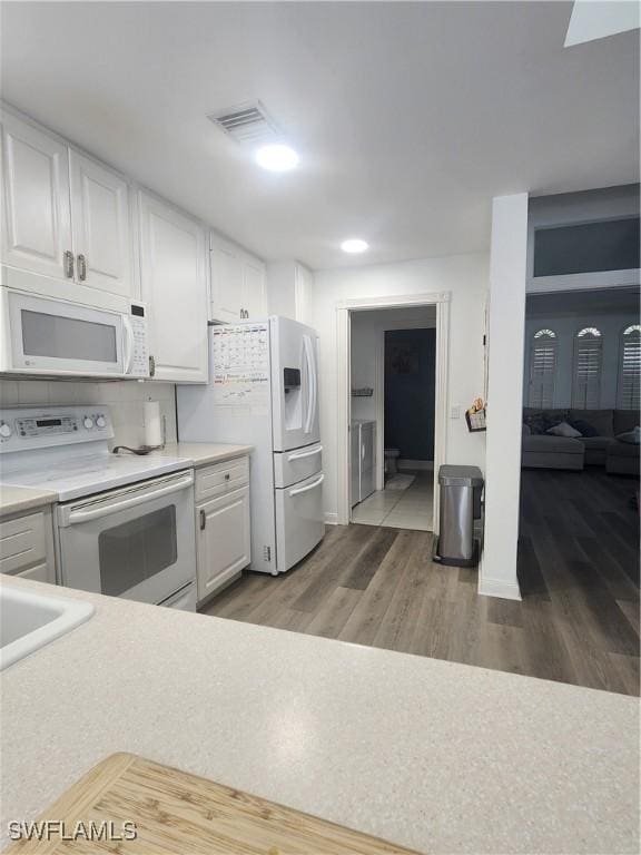 kitchen featuring white appliances, white cabinets, light countertops, and light wood-style flooring