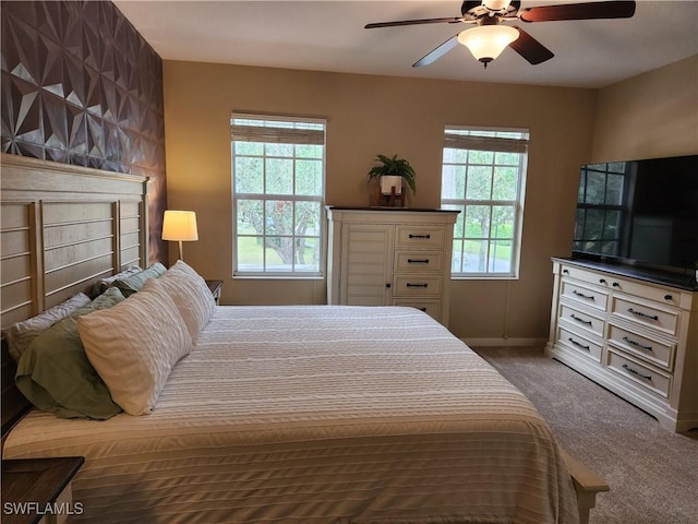 carpeted bedroom with baseboards and ceiling fan