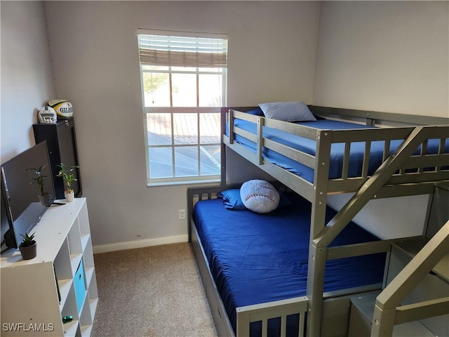 carpeted bedroom with multiple windows and baseboards