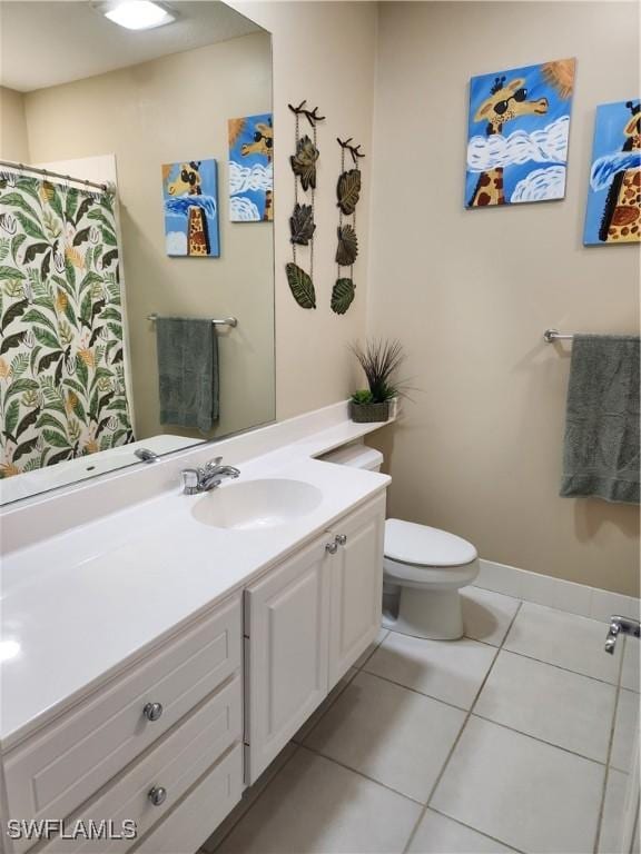 bathroom with tile patterned flooring, vanity, toilet, and baseboards