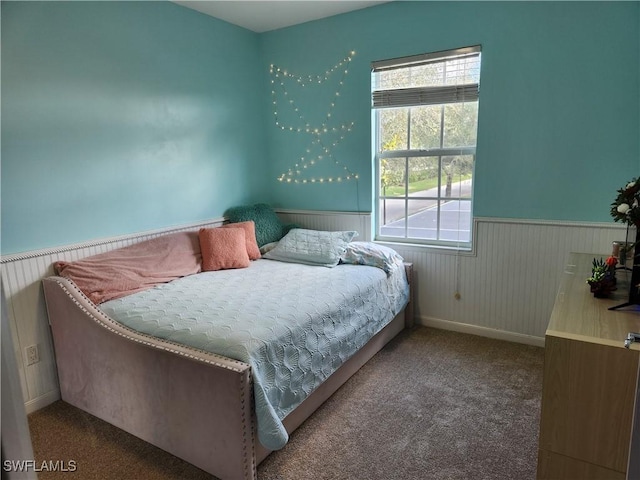 carpeted bedroom featuring wainscoting
