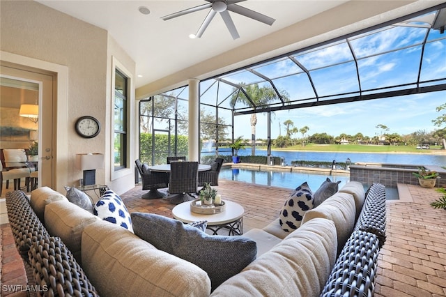 view of patio / terrace featuring a water view, a lanai, an outdoor pool, and an outdoor living space