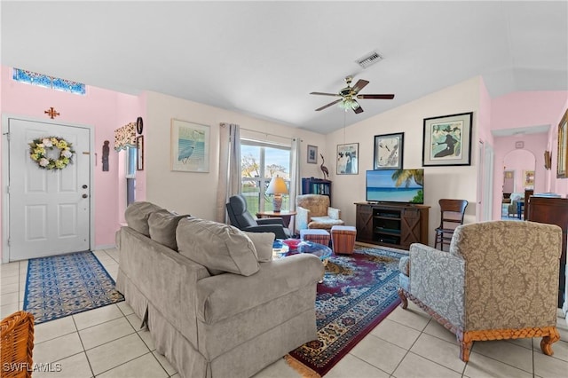 living area featuring visible vents, arched walkways, lofted ceiling, and light tile patterned flooring