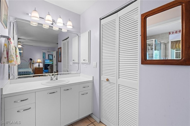 bathroom featuring tile patterned flooring, connected bathroom, a stall shower, a closet, and vanity