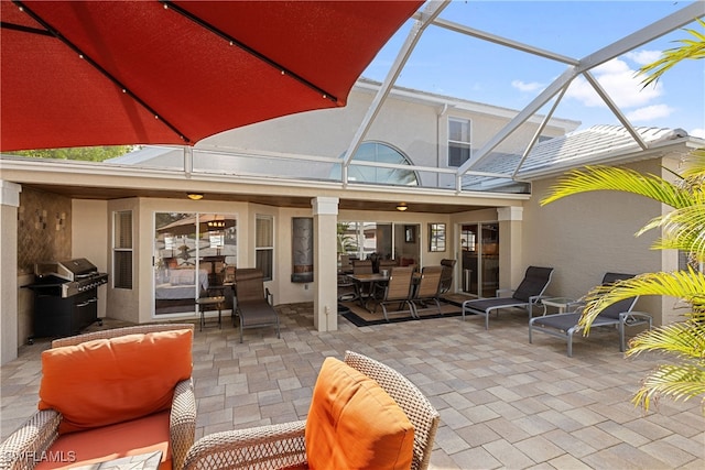 view of patio featuring glass enclosure and a grill