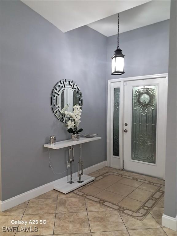 foyer featuring baseboards and light tile patterned floors