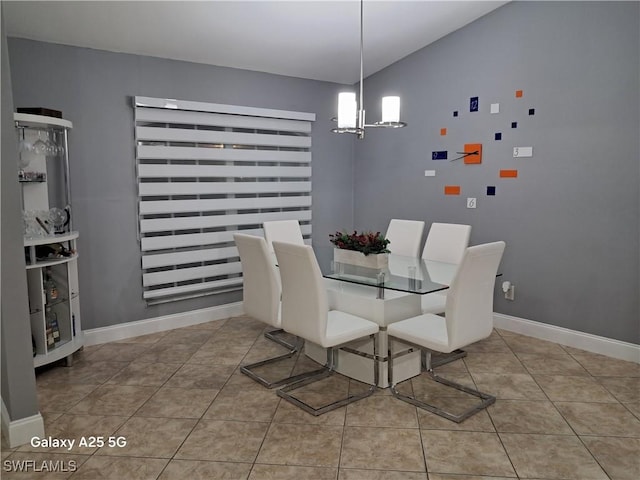 tiled dining area featuring baseboards and a notable chandelier