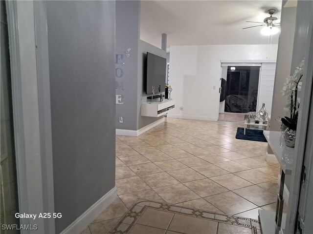 hallway featuring baseboards and light tile patterned floors
