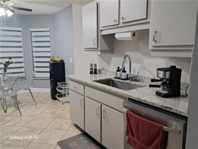 kitchen with dishwasher, light tile patterned floors, a sink, decorative backsplash, and ceiling fan
