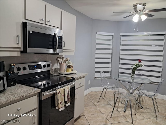kitchen featuring ceiling fan, baseboards, white cabinetry, and stainless steel appliances