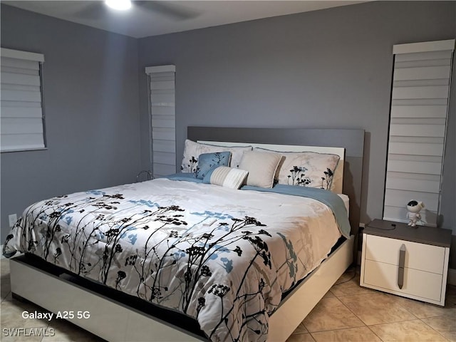 tiled bedroom featuring ceiling fan