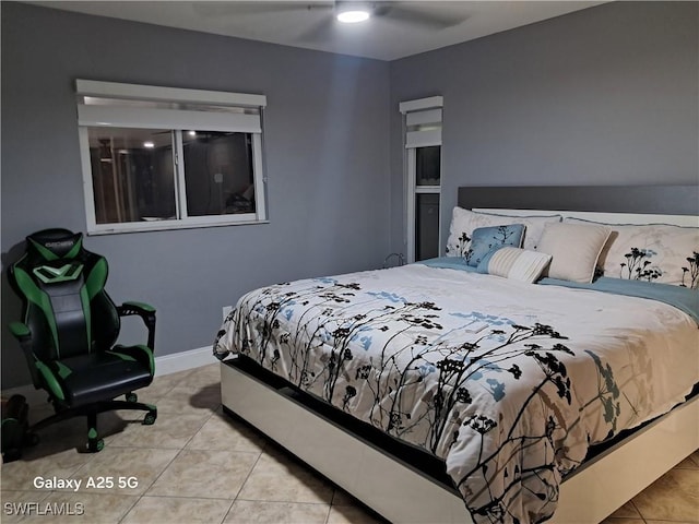 bedroom with tile patterned floors, baseboards, and ceiling fan