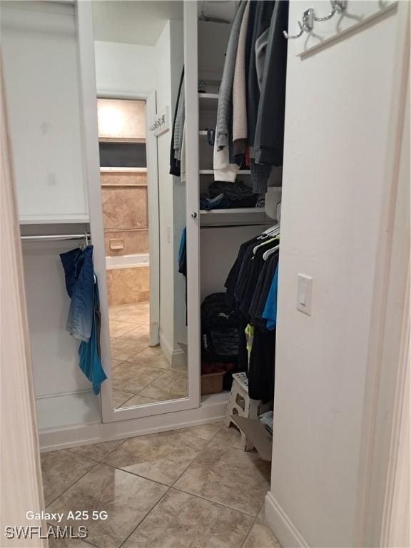 walk in closet with tile patterned floors