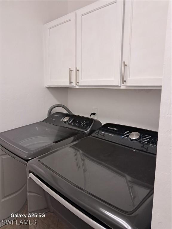 clothes washing area with cabinet space and washer and clothes dryer