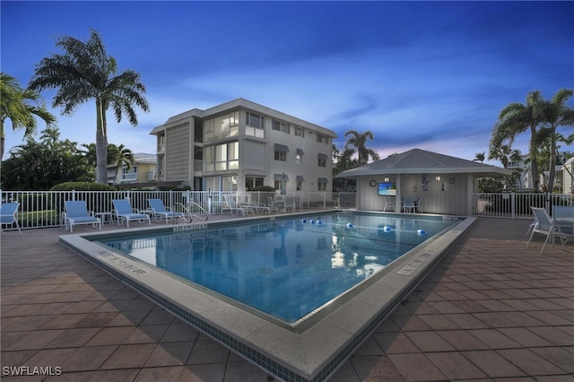 pool with a patio and fence