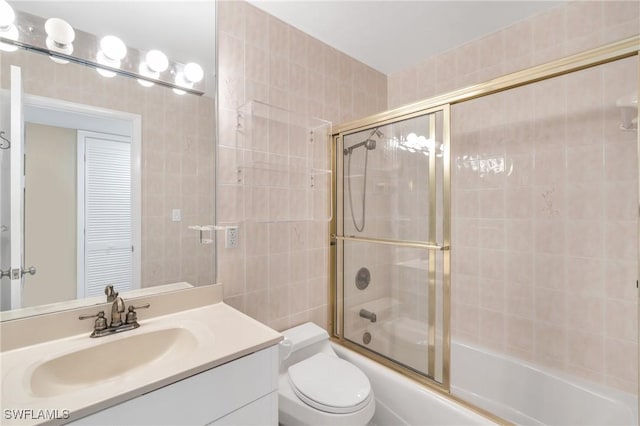 bathroom featuring toilet, enclosed tub / shower combo, and vanity