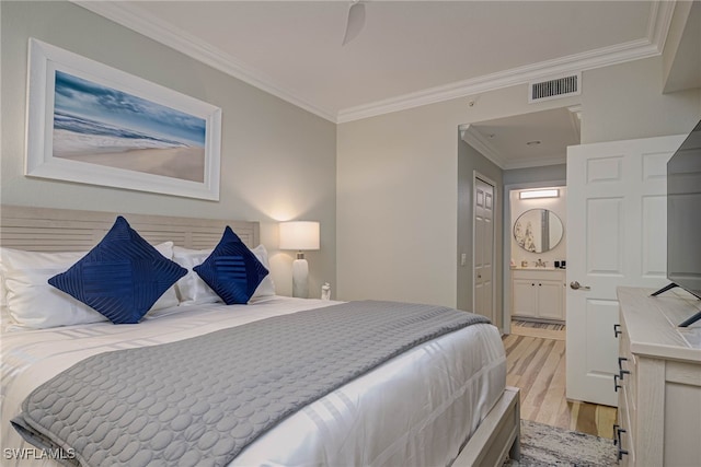 bedroom featuring ornamental molding, visible vents, light wood-style flooring, and ensuite bathroom