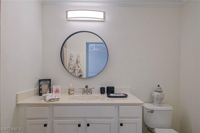 bathroom with toilet, ornamental molding, and vanity