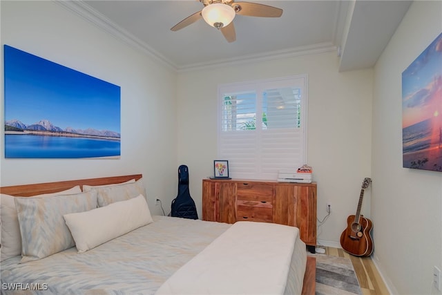 bedroom featuring ceiling fan, baseboards, crown molding, and wood finished floors