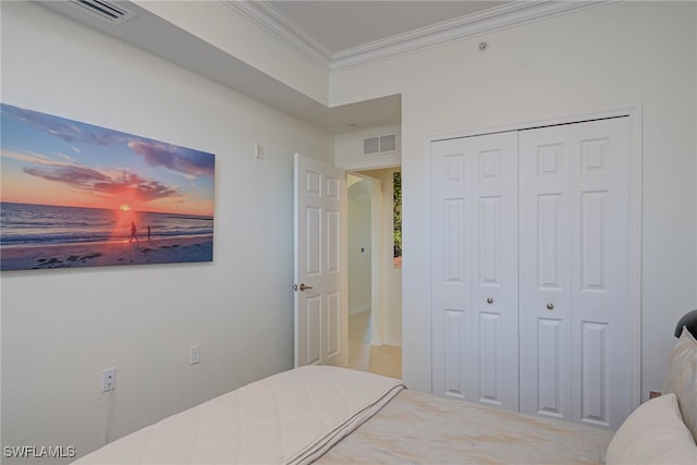 bedroom with a closet, visible vents, and crown molding