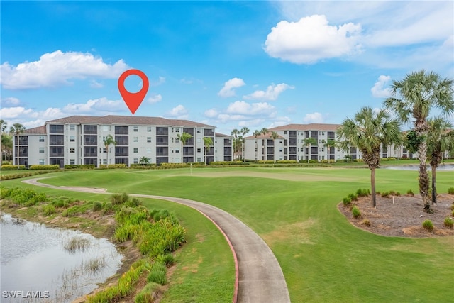 view of home's community featuring golf course view and a lawn