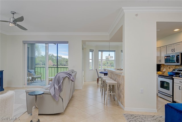 living area with light tile patterned floors, plenty of natural light, and ornamental molding